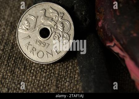 1 Krone Harald V. Norwegian coin and stones on natural linen fabric. Business and finance. Stock Photo