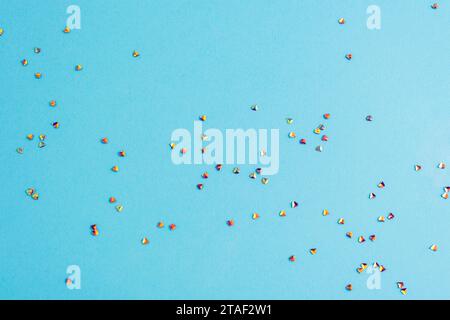Golden confetti on light blue background. Winter holidays, Christmas or birthday concept. Stock Photo