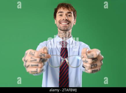Handsome businessman with eyeglasses on green background Stock Photo