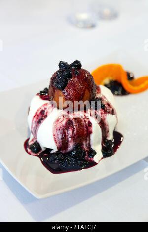 Traditional Romanian papanasi fried doughnuts topped with sour cream and blueberry preserve, Crama Romaneasca restaurant, Surrey, England Stock Photo