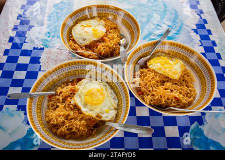 Noodles and omelette served in bowls for breakfast on a table. Stock Photo