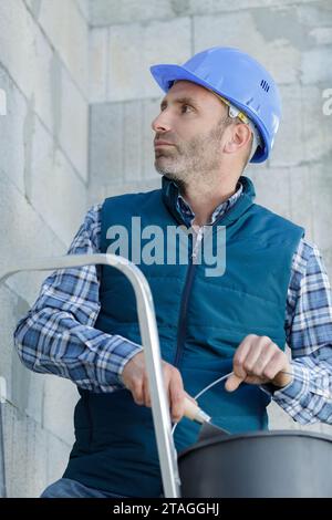 contractor employee applying plaster outdoors Stock Photo