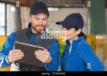 male and female builders using tablet in construction site Stock Photo