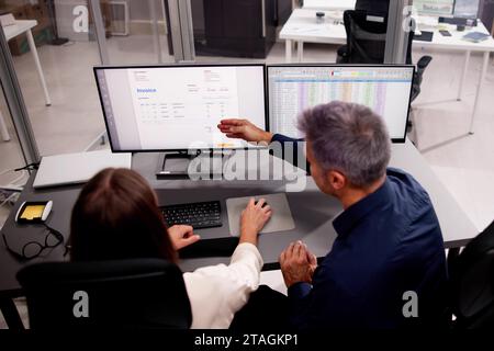 Working Analyst at Desktop PC with Multiple Spreadsheets Stock Photo
