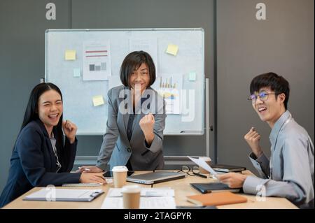 Group of cheerful and excited, diverse Asian businesspeople are celebrating their project success in the meeting together. project approved, campaign Stock Photo