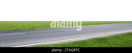 Asphalt road with green grass beside it isolated on white background with clipping path Stock Photo