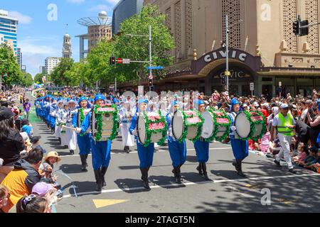 A group of drummers, their drums decorated with tinsel and 'Merry Christmas' signs, take part in the Farmers Christmas Parade in Auckland, New Zealand Stock Photo