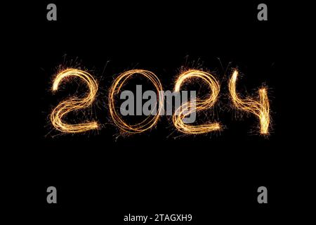 New Year 2024 light. Sparklers draw figures 2024. Bengal lights and letter. Holidays. Luxury Stock Photo