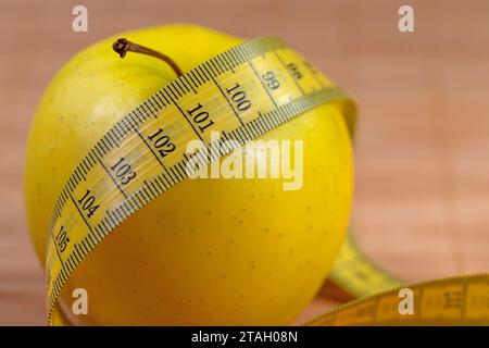 Apple and tape measure, symbolic of weight reduction Stock Photo