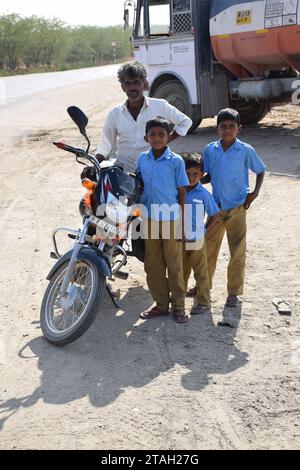 Indian man with his kids and motorbike on the road to Jodhpur, Rajasthan - India Stock Photo