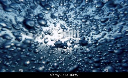 Air bubbles rising elegantly from the sea bottom to the water's surface, accompanied by a diver's breath. Ideal for crafting an abstract and calming n Stock Photo