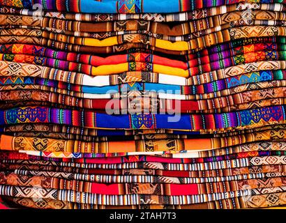 Stack of multicolored andean textile and fabrics in Pisac traditional market, Peru Stock Photo