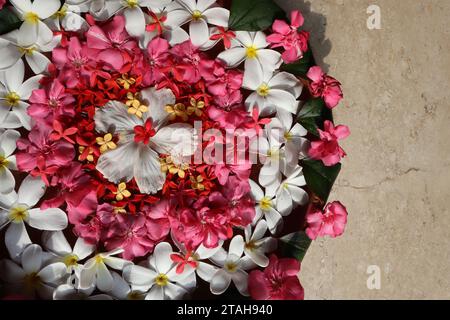 Beautiful Floating flower decorations done in large clay flat pot. Flower decoration in water with Plumeria and Oleander flowers with Hibiscus in cent Stock Photo