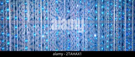 Blue and turquoise background of LED flashing, blinking and flickering bulbs. Disco and holiday illuminated neon shiny backdrop. Abstract wall decorat Stock Photo