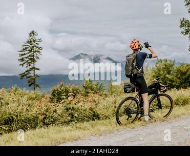 off road cyclist takes a drink of water with katahdin in background Stock Photo