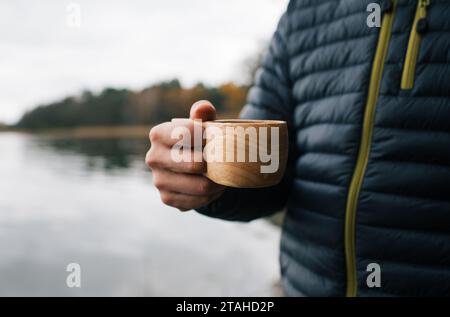 person holding a reusable cup to drink coffee outdoors Stock Photo