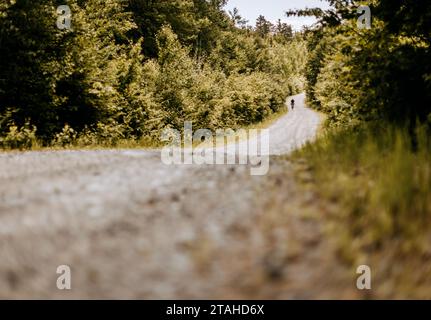 Cyclist rides his bike on remote gravel road katahdin woods and waters Stock Photo