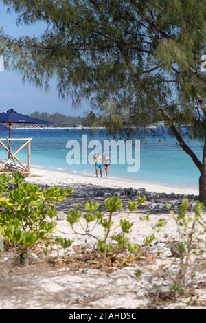 Couple exiting the sea at sandy beach of Gili Meno Stock Photo