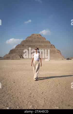 Latin woman with sunglasses, walking in front of Saqqara pyramid Stock Photo