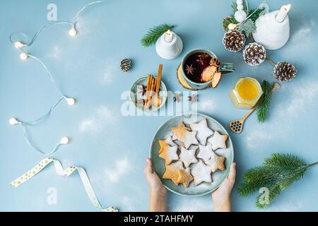 Hands holding Plates with Gingerbread stars, christmas decorations. Stock Photo