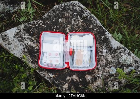 First aid kit in the open form lies on a stone, a first-aid kit. Stock Photo
