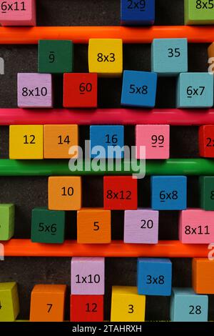 Many colorful cubes with numbers, multiplications and pencils on dark grey table, flat lay Stock Photo