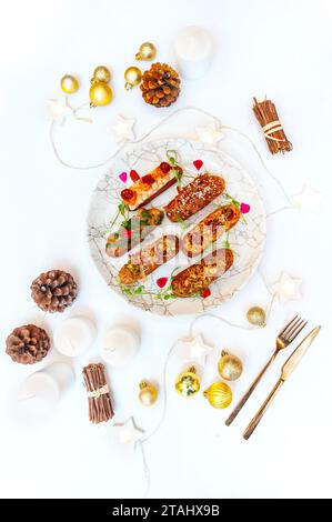 Eclairs on a marble plate on a background with Christmas or New Year decor. High quality photo Stock Photo