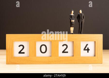 2024 new year concept. Man and woman figurine on top of 2024 sign. Copy space Stock Photo