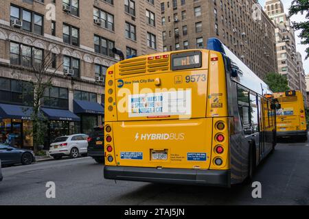 New York, NY, US-September 9, 2023: Yellow hybrid city bus on Manhattan street. Stock Photo