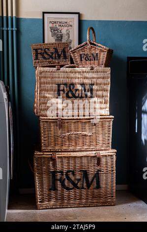 Stacked Fortnum & Mason picnic hampers in Georgian barn conversion, Tetbury, Gloucestershire, UK. Stock Photo