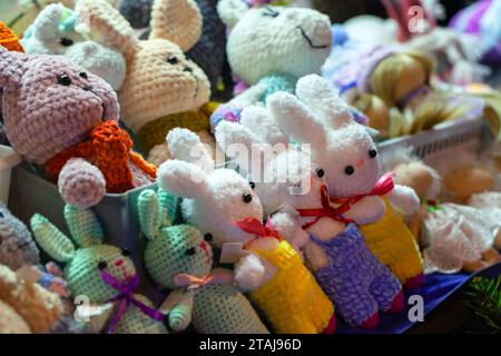 Colorful rabbits, handmade knitted toys lay on the counter in a gift shop Stock Photo