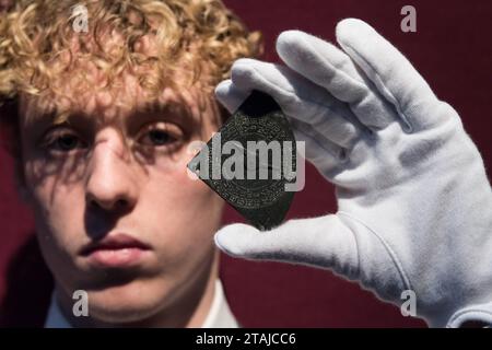 LONDON, UNITED KINGDOM - DECEMBER 01, 2023: A technician holds the master of the Chetwode Quadrant, an English horary quadrant, circa 1311, the earliest dated English scientific instrument (estimate: £100,000-150,000) during a photocall at Christie's auction house showcasing the highlights from the Classic Week Sales in London, United Kingdom on December 01, 2023. Spanning art from antiquity to the 21st century, with six live auctions and one online sale, the Classic Week Sales series will run from 1 to 15 December. (Photo by WIktor Szymanowicz/NurPhoto) Stock Photo