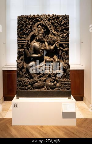 London, Uk - 18 April 2022: Granite statue of the divine Hindu couple, the great God Shiva and His wife Parvati. AD 1100-1300, Orissa, India and house Stock Photo