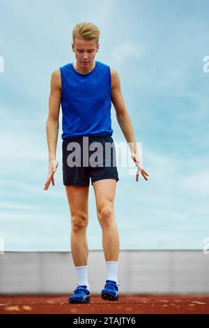 Take off. Focused runner propelling into sand pit. Young man ...