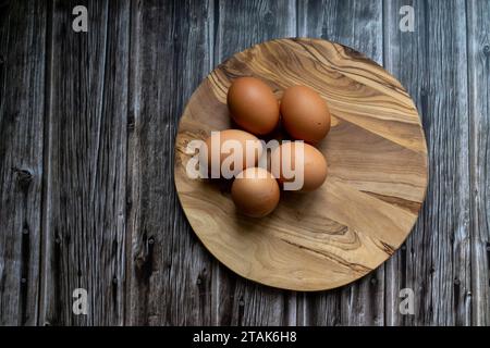 Eggs on wooden plate, raw ingredients Stock Photo