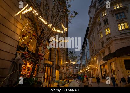 London, UK - Nov 20 2023: Glasshouse Street just off Piccadilly Circus in central London. People walking along the street with Christmas lights Stock Photo