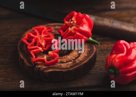 Slices of Fresh Red Habanero Pepper on a Wooden Surface Stock Photo