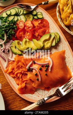 breakfast, brunch tray spread full of fixings for making a bagel with lox: arugula, avocado, tomato, cucumber, red onion Stock Photo