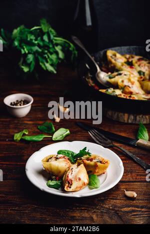 Baked jumbo shells pasta stuffed with ground beef, spinach and cheese on white plate Stock Photo