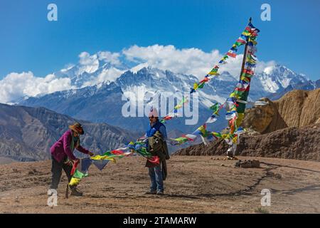 Prayer flags on the  pass from Yara to Tange village with views to the west of Jakriojagga Peak - Upper Mustang District, Nepal Stock Photo