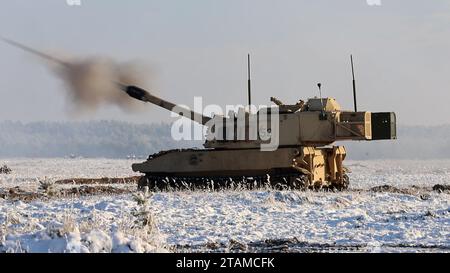 The sound of artillery thunder! Paladin M109 Howitzer assigned to the Bravo Battery, 4th Battalion, 27th Field Artillery Regiment, 2nd Armored Brigade Combat Team, 1st Armored Division, begin the joint live fire exercise during the US-Polish MARS 23 LFX in Toruñ, Poland on December 1, 2023. The Paladin M109 is an American 155 mm turreted self-propelled howitzer, first introduced in the early 1960s to replace the M44. Soldiers from the 2nd Armored Brigade Combat Team are stationed throughout Europe to support Operation European Assure Deter and Reinforce. (Photo by U.S. Army Spc. Trevares Johns Stock Photo
