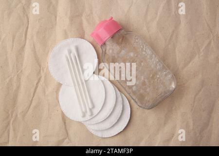 Makeup remover, cotton swabs and pads on crumpled paper, flat lay Stock Photo