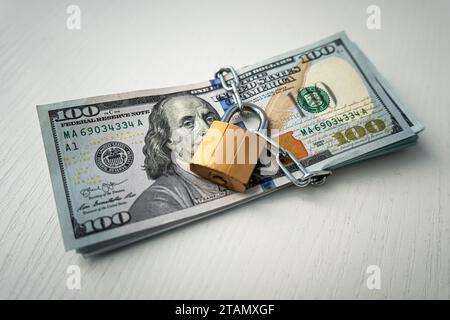 money dollars in a chain with a lock on the background of white. The concept of banning dollars. the concept of keeping or banning cash dollars. money Stock Photo