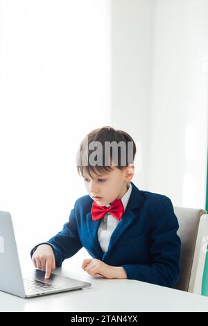 Business boy in jacket sitting at laptop Stock Photo