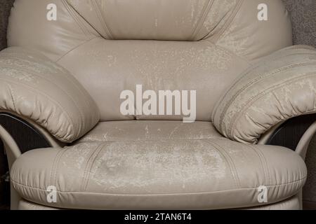 Defects on a white leather sofa. Damaged to leather furniture. Stock Photo