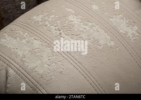 Defects on a white leather sofa. Damaged to leather furniture. Stock Photo