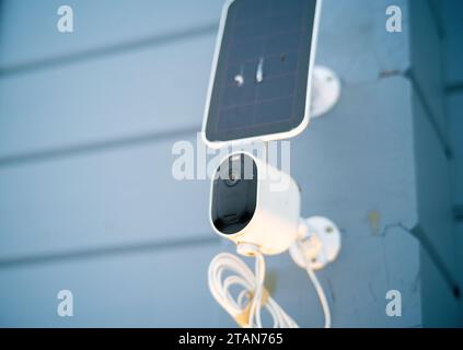 a solar battery and cctv camera mounted on the wall, outdoor closeup Stock Photo