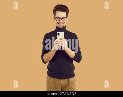Portrait of young cheerful man using mobile phone Stock Photo