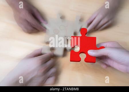Hands helping to put together a jigsaw puzzle Stock Photo