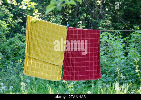 a red and yellow towel is hanging on a string to dry Stock Photo